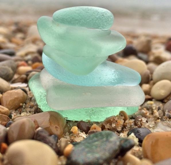 sea glass stacked on top of each other on gravel