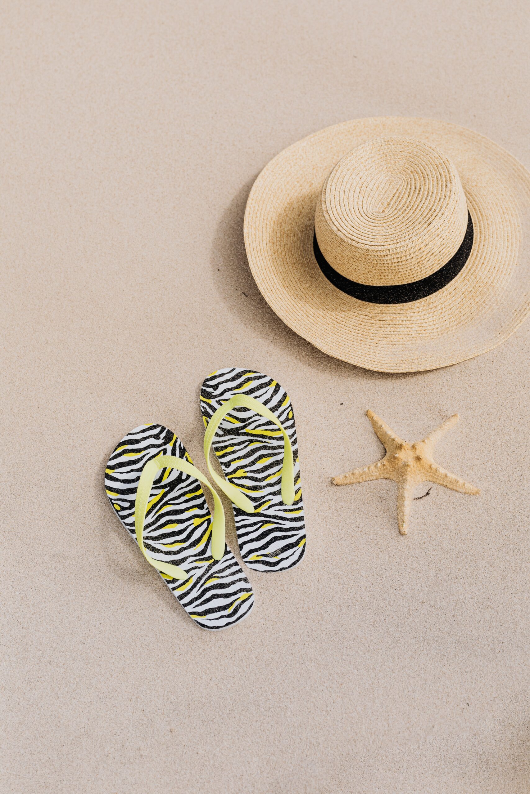 beach-hat-flip-flops-and-a-starfish-on-the-sand